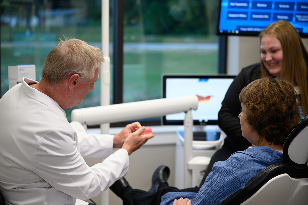dr_randall_showing_teeth_model_to_patient_in_chair patient care rivertown dental